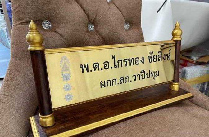 ป้ายชื่อตั้งโต๊ะไม้สัก ติดแผ่นสแตนเลสทองกัดกรด ตกแต่งด้วยหัวบัวทำสีทอง ขนาดแผ่นทอง 11x36ซม.