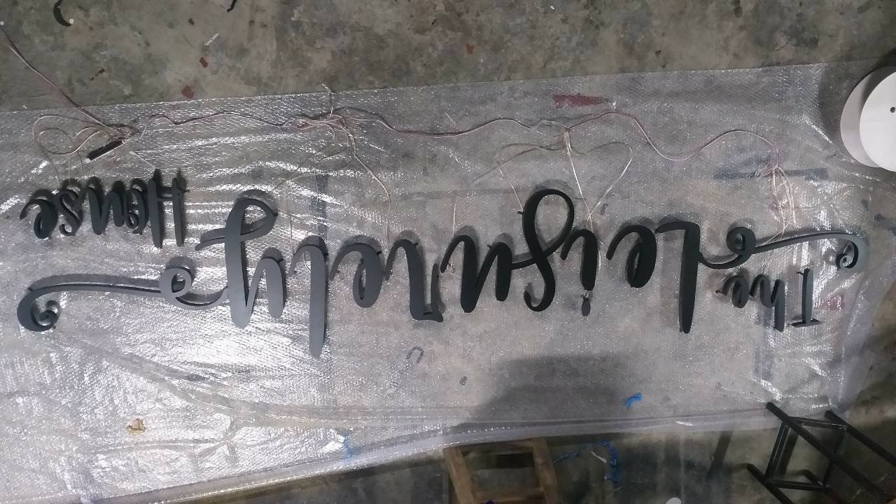 งานป้ายสแตนเลสตัวอักษรพ่นสีดำ ไฟออกหลัง The Leisurely House