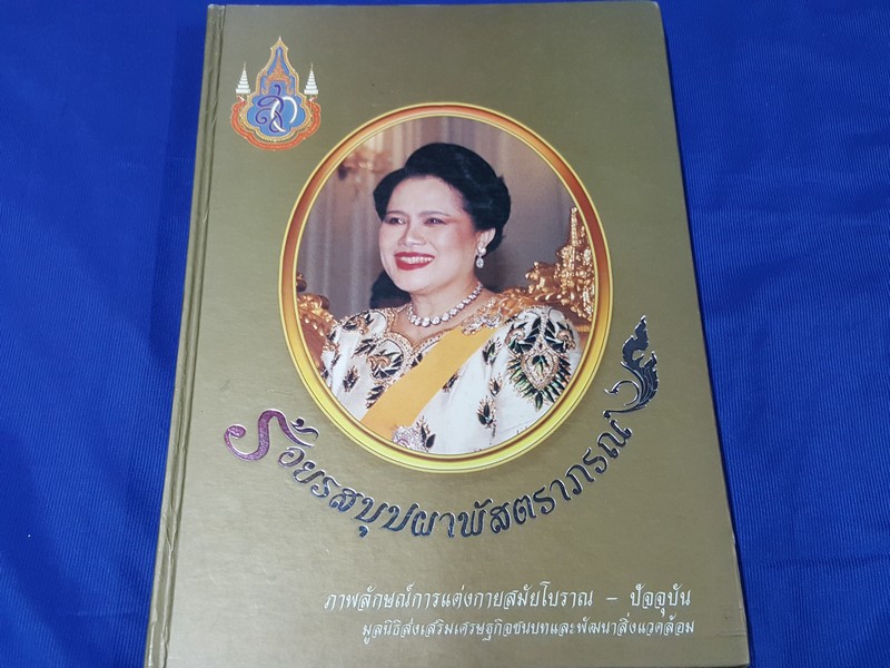 ร้อยรสบุปผาพัสตราภรณ์ ภาพลักษณ์การเเต่งกายสมัยโบราณ-ปัจจุบัน โดย มูลนิธิส่งเสริมเศรษฐกิจชนบทเเละพัฒนาสิ่งเเวดล้อม ปกแข็ง ปี 2547