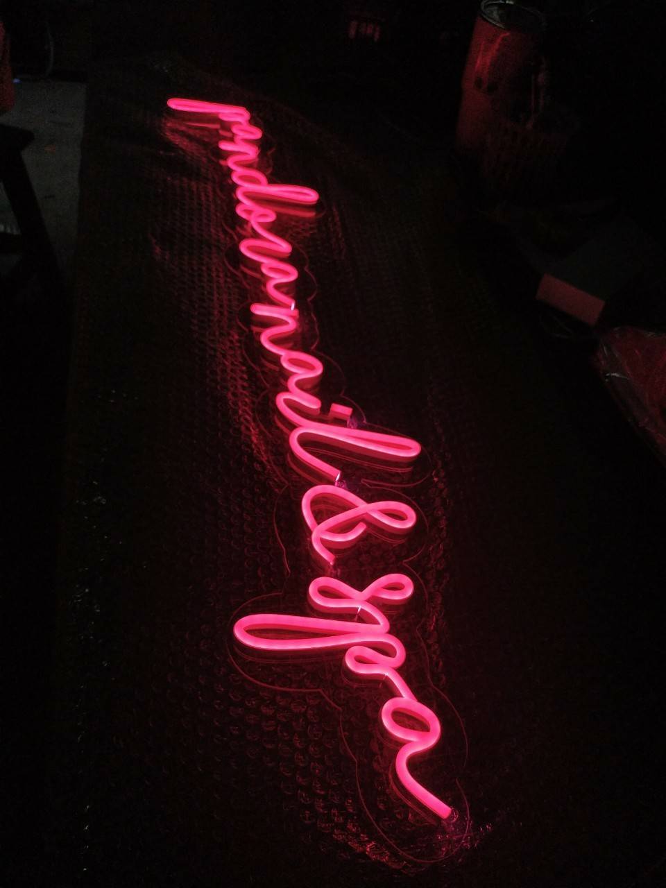 ป้ายไฟนีออนดัด แสงสีชมพู - วางบนแผ่นอะคลิคิลใส