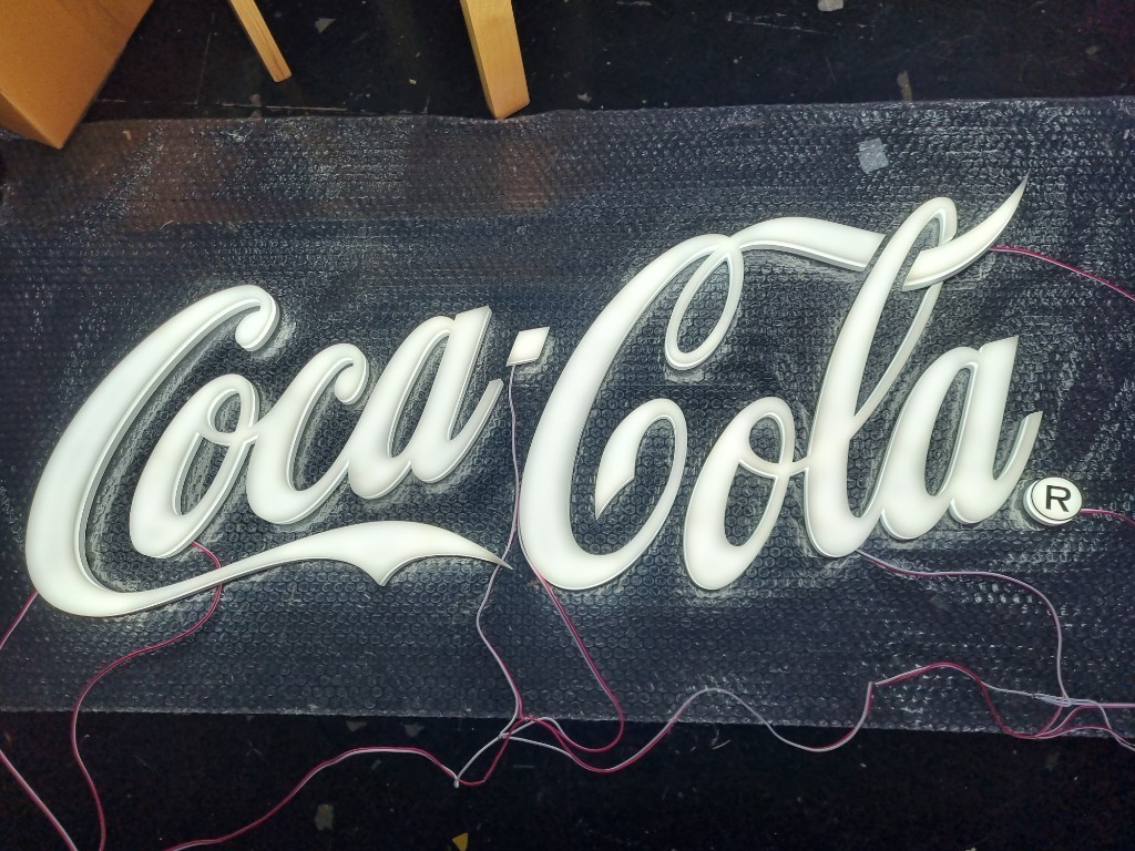 อักษรไฟออกรอบตัว ''โคคา โคล่า''