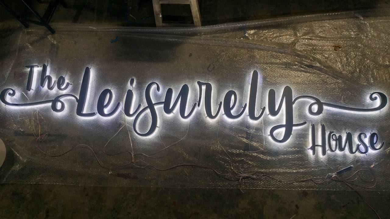 งานป้ายสแตนเลสตัวอักษรพ่นสีดำ ไฟออกหลัง The Leisurely House